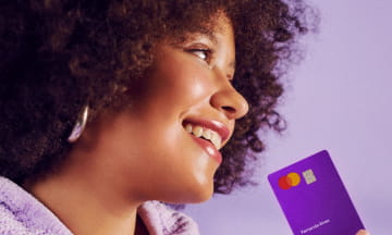Woman in profile holding a Nubank purple card