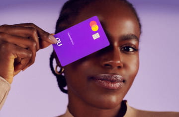 Image of a man holding the purple card next to his eye